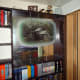 DVDs and Blu-ray discs removed from the area where I would be working to fit the new shelves; revealing the decorative mirrored picture behind.