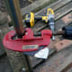 Cutting the chrome bar using a pipe cutter.