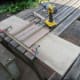 Salvaging plywood from an old jig for recycling as under table shelf.