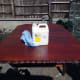 Cleaning table top with white spirit after light hand sanding, prior to applying final coat of wood stain.