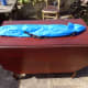 Redundant blue carry bag for broken folding chair repurposed as storage bag for the removable table arms and Chrome legs for drop leaf table top support.