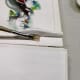 Applying glue with a brush to a book's spine. I used a small, flat brush to apply the PVA glue.