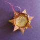 Punch a hole into the top. Slip in and tie a length of ribbon, string, or fish line.