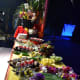 Buffet of food with lots of fruit and flowers for decoration.