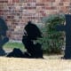 Black figure of cowboy bowing before cross is a unique display.