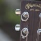Wedding rings hanging from the bolts of a guitar