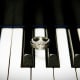 Black and white photograph of her wedding ring between piano keys