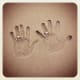 His and her handprints with rings on sand