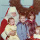 Santa has his hands full. Don't you love the expression of the girl in red, on the right?