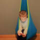 Hammock huddling boy with autism; Aiden playing with phone in Hammock