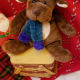 A plush reindeer perches on a basket that's too large for the tree.