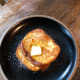 Place the toast on a plate. Cut some butter and sprinkle some powdered sugar on top.