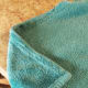 Lay your blanket flat. Starting on one side, begin folding the corner in.