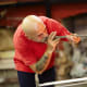 Blowing into the incandescent glass to inflate it.