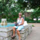 My mom sitting near a fountain on the grounds of the Alamo