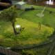 Bill's Backyard is O gauge figures riding on an N gauge train in a suburbian backyard complete with Hills Hoist.
