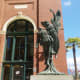 A view of the sculpture that shows the angel's raised hand and the missing wreath