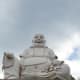 Budai statue sits humbly outside in the pagoda.