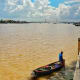A local man is fishing with the Rach Mieu Bridge in the backdrop.
