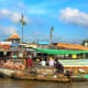 Each boat has a tall pole with the fruit(s) on sales to inform customers of what it's trading.