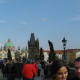 Crowds mingle with the statues on Charles Bridge.