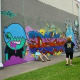 People admiring graffiti murals across from Baldwin Park