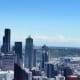 View from the Space Needle in downtown Seattle with Mt. Rainier stick up above the clouds on the horizon.