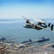 An E-2D Hawkeye flies over Naval Base Norfolk in Norfolk, VA