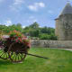 An old wooden wagon, filled with flowers, sits near the gate of Sierck.