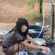 Alisa does the daily chore of dish washing. Water isn't a problem in the village; but hot showers do require a kettle!