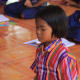 Little girl taking lessons in Buddhism at the local centre in Nanokhong