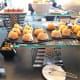 Savory filled buns and accompaniments, with scones and jam behind.