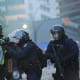 Riot police firing tear gas cannisters