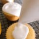 Spread the frosting on top of the cupcakes.