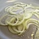Sliced onions in a pan with olive oil