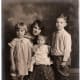 My mother is sitting on her mother's lap alongside her sister and brother.
