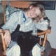 This shows Sarah relaxing at home with Moses in her lap.