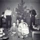 My parents and brothers seated with both sets of grandparents on either side of our Christmas tree.