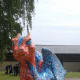 Norvica Serafina, meaning 'Fiery One', by Norwich School, standing in Cathedral Close. The scales were created using finger prints of the staff & pupils of the school.