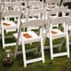 White wooden or resin folding chairs like these typically rent for around $2–5 per.