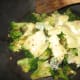 When broccoli is done, add cheese and reduce heat.