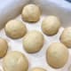 Arrange the dough balls on a baking pan that is lined with parchment paper.