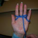 After pulling the old strand of yarn over from the back of your little finger, wrap the yarn back behind your ring finger.