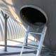 The ladder is bolted to the rim of the manhole, and stabilized with a bracket attached to a spoke.