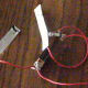 Attach the the stripped end of the third copper wire to the light bulb and socket. Attach the other stripped end of the wire to the second electrode. Your salt water circuit is ready to use.