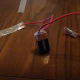 Attach the other stripped end of the same wire to the light bulb and socket. Attach a second copper wire to the negative terminal of the battery and the other stripped end to the top of the aluminum electrode.