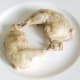 Cooked chicken legs are removed from pot with slotted spoon
