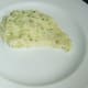 Mashed potato is plated in a shape ready to accommodate the chicken leg
