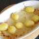 Potatoes are carefully stirred around in the goose fat