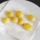 Goose fat roasted potatoes are drained on kitchen paper prior to being plated for service